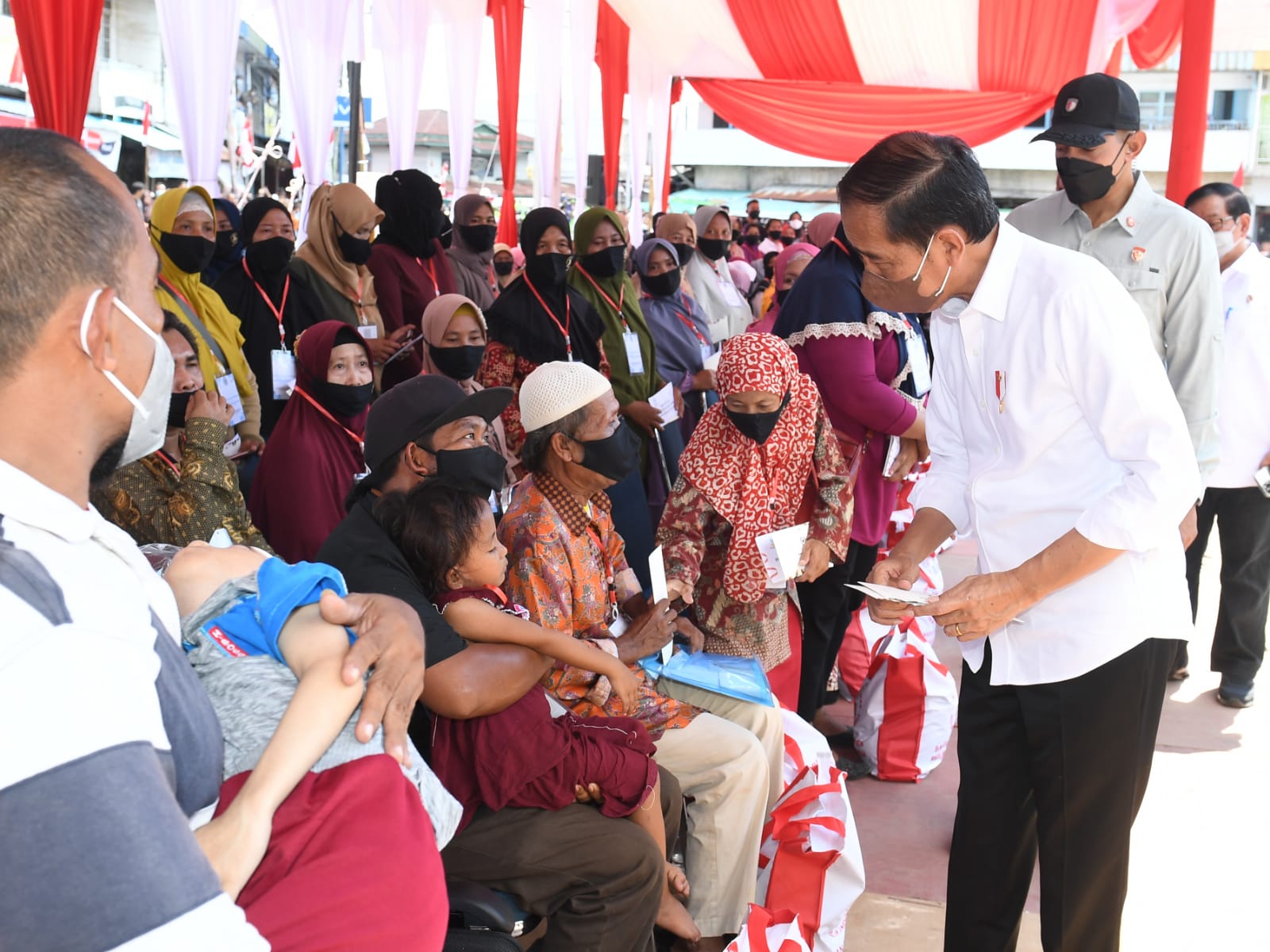 Presiden Jokowi didampingi Ibu Iriana Joko Widodo menyerahkan BMK dan BLT minyak goreng kepada peserta Program Keluarga Harapan (PKH) di Pasar Sungai Duri, Kabupaten Bengkayang, Provinsi Kalimantan Barat, Selasa (09/08/2022)