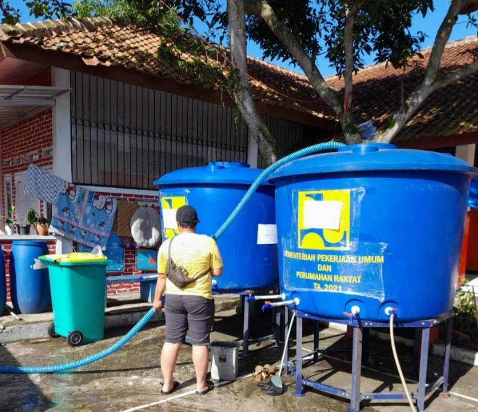 Seorang sedang mengisi air bersih untuk masyarakat Cianjur ke dalam tangki penampungan air. Dokumentasi/ PUPR