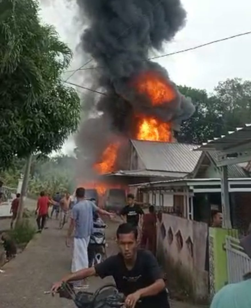 Warga saat ikut memadamkan api di gudang BBM yang terbakar di Dusun III Desa Cinta Kasih Kecamatan Belimbing Kabupaten Muara Enim, Senin (19/12/2022)