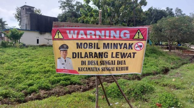 Spanduk larangan mobil angkutan minyak melintas di Desa Sungai Dua, Kecamatan Sungai Keruh, Musi Banyuasin